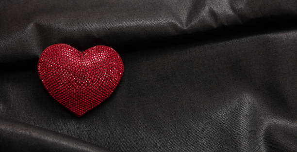 istock Valentine day, love celebration. Red color ruby heart jewel on empty black background. 1367694533