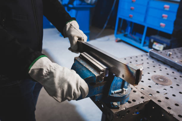 istock Close up of human hands working in workbench with metal pieces. 1367698547
