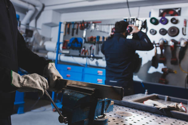 istock Close up of human hands working in workbench with metal pieces. 1367698548