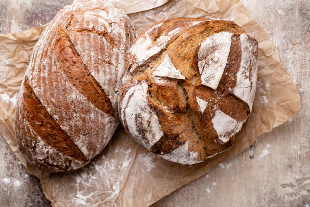 istock Assortment of baked bread on wooden table background. 1367698579