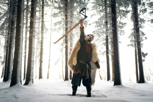 istock Medieval warrior celebrating the win at the battle with arms raised while holding the sword 1367706130