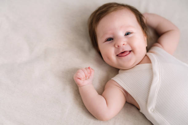 bambina carina di 2 mesi sorridente - lying on back foto e immagini stock