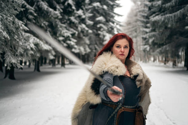 Portrait of medieval female warrior, holding the sword, ready for battle