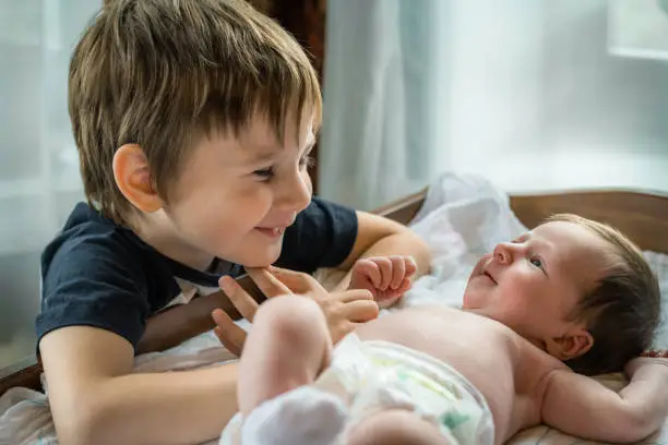 Photo of Little boy meeting his cute baby sister