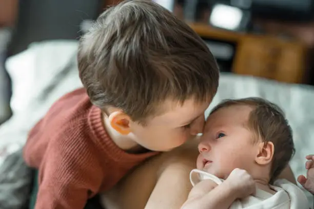 Photo of Little boy meeting his cute baby sister