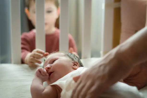 Photo of Little boy meeting his cute baby sister