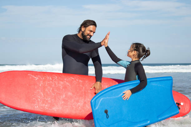istock Bright father and daughter doing sports on cloudy beach 1367708891