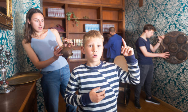 istock Smart preteen boy gesturing with forefinger in quest room 1367710297