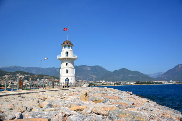istock white lighthouse on mountains and blue sky background, Alanya Turkey 1367711643