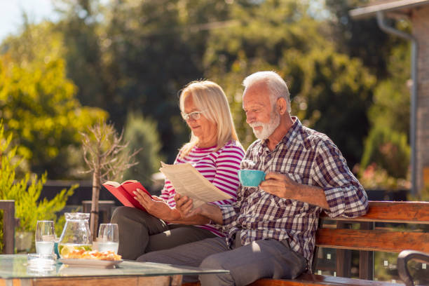 istock Senior couple drinking coffee outdoor and reading 1367712671