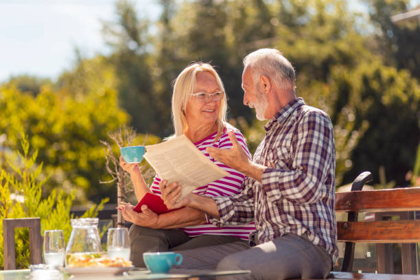 istock Senior couple reading and drinking coffee outdoor 1367712683