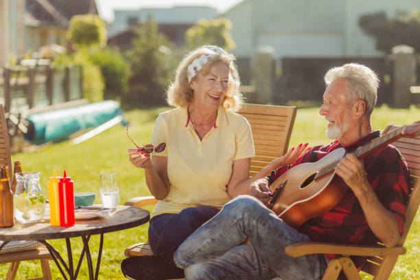 istock Senior couple playing the guitar and singing while having outdoor lunch 1367712695