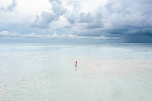 istock Woman walking on sandbar 1367714210