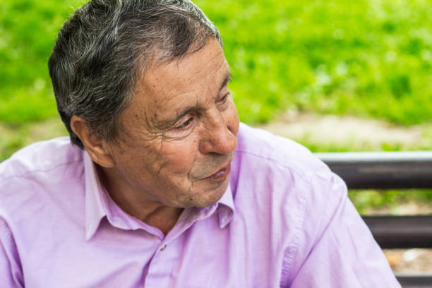 istock Senior man sitting on bench in the park 1367716266