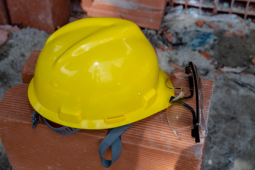 Yellow protective helmet on pile of red bricks, at construction site. Sao Paulo city, Brazil.