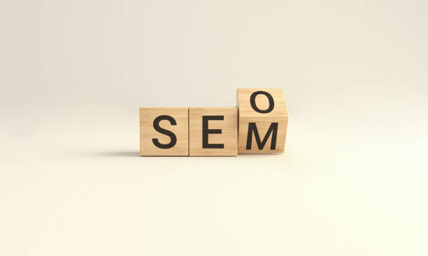 istock SEO vs SEM. Wooden cube block flip over word SEO to SEM on Yellow studio background. 1367719371