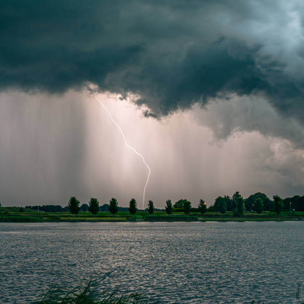 dodatnie wyładowania atmosferyczne z chmury do ziemi w pobliżu jeziora o zmierzchu - violent wind zdjęcia i obrazy z banku zdjęć