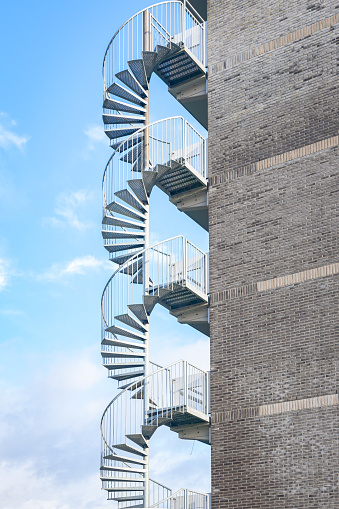Metal circular stairs as escape route on the edge of an apartment building.