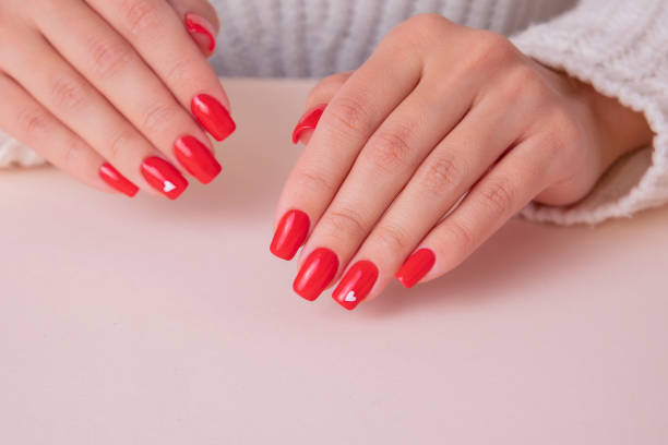 istock Female hands with red manicure nails, hearts design 1367728619