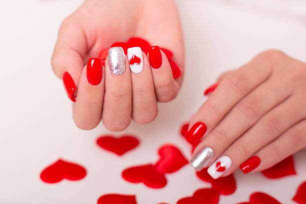 istock Female hands with red manicure nails, hearts design 1367728753
