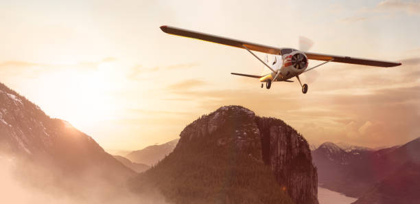 istock Airplane flying over the mountain landscape during sunset. 1367734510