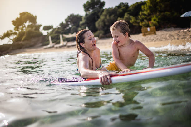 istock Mother and son enjoy surfboarding 1367737628