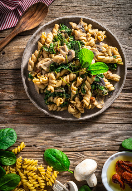 Fusilli with mushrooms Italian food vegan plant based recipe Med Fusilli with mushrooms Italian food vegan plant based recipe Mediterranean diet with ingredients as fusilli pasta, dried tomato, vegan cheese, shallots, garlic, chili, coconut milk, mushrooms, spinach, soy sauce, paprika spinach pasta stock pictures, royalty-free photos & images