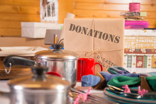 Disaster Relief package wrapped in brown paper and tied with string.  Various kitchen items on display around the brown paper wrapped Relief box.