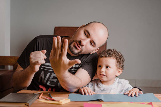 Dad teaching his son to count numbers with his hands stock photo