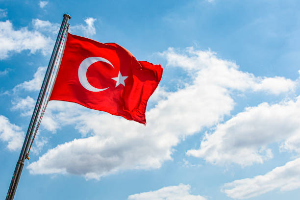 istock National Turkish flag waving on the wind, against blue sky 1367740714