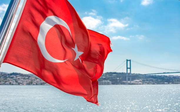 istock National Turkish flag waving on the wind, against blue sky 1367740715