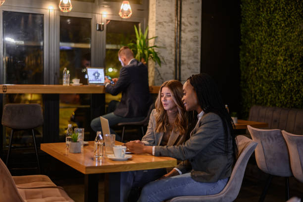 istock Two businesswoman having a meeting in a cafe while using a laptop 1367742660
