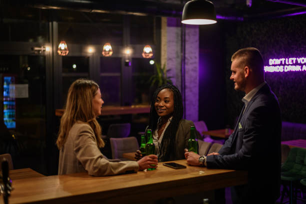 istock Cheerful colleagues drinking beer in the bar together after work 1367742662
