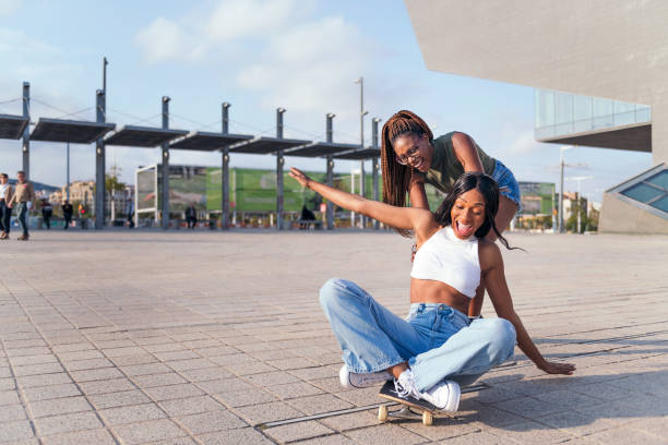 istock friends laugh in amusement playing with skateboard 1367742845