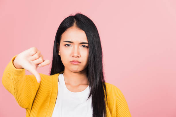 istock woman unhappy, negative gesture showing finger thumbs down 1367748471