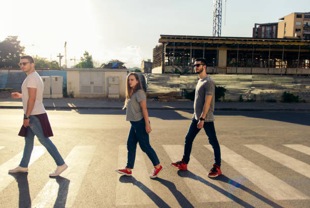 istock Three friends crossing a zebra crossing on sunset 1367750148