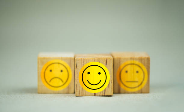 istock Choose square wooden block with a face grin emoticons. A survey, poll, or questionnaire based on user experience 1367751541