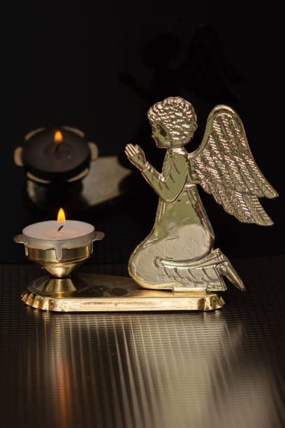 istock a golden angel and a candle 1367754345