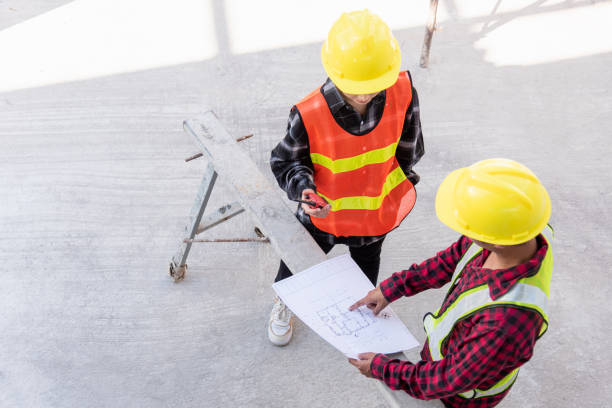 istock Architect and client discussing help create plan with blueprint of the building at construction site floor. Asian engineer foreman worker man and woman meeting and planning construction work, top view 1367755005