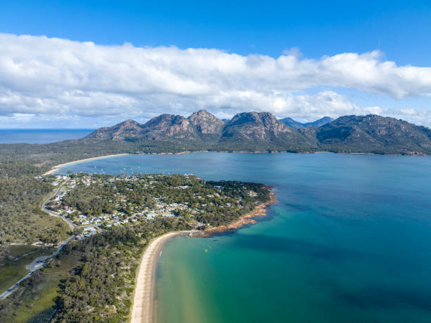 vista aerea ad alto angolo del drone di coles bay con richardsons beach e la catena montuosa hazards sullo sfondo, parte del freycinet peninsula national park, tasmania, australia. spiaggia di muirs in primo piano - freycinet national park foto e immagini stock