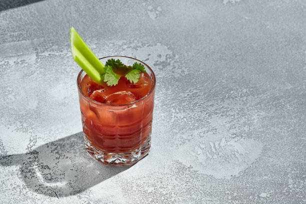 red bloody mary cocktail é um coquetel de baixo teor alcoólico com vodca e suco de tomate. mesa vintage com sol e sombra. bloody mary ou virgin mary drink - coquetel à base de vodca decorado com aipo. - lemon juice horizontal composition fruit - fotografias e filmes do acervo