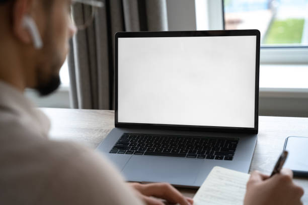 istock Young man working on laptop with blank copy space screen from home office 1367759461