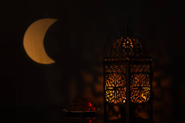 istock Lantern and small plate of dates fruit with moon shape from light on background 1367759501