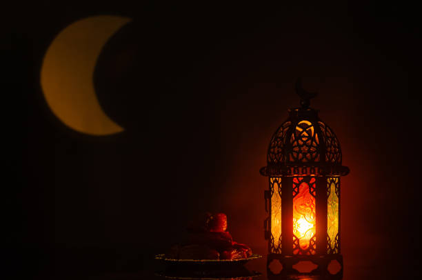istock Lantern and small plate of dates fruit with moon shape from light on background 1367759502