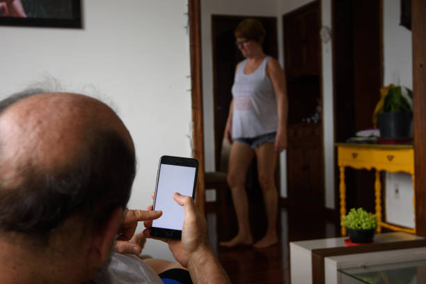 istock An old man using the phone at home sitting on the sofa 1367764298