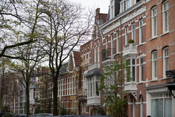 A number of houses in the traditional Dutch architectural style. Triangular roofs with orange tiles. A number of colorful old houses in Europe.