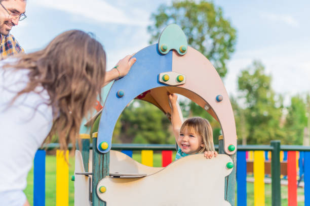 istock A boy playing in the playground with his adoptive parents. 1367769472