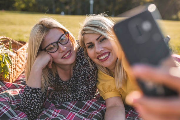 istock Smiling sisters taking selfie on sunny spring day in park 1367771943