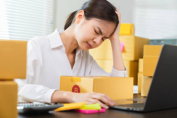 istock Small business, asian woman headache because there is a problem in management, delivery with packaging. 1367776812