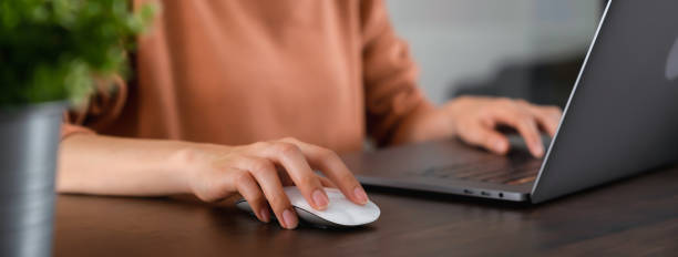 버튼을 누르면 컴퓨터 마우스를 누르고 테이블에 노트북을 사용합니다. - 컴퓨터 마우스 뉴스 사진 이미지